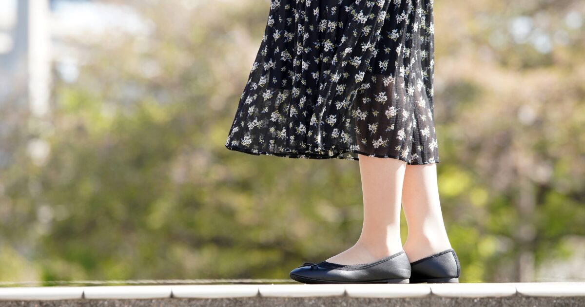 黒い花柄ワンピースとバレエシューズの足元