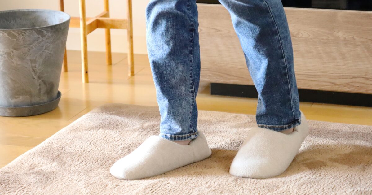 スリッパを履いたジーンズ姿の足元