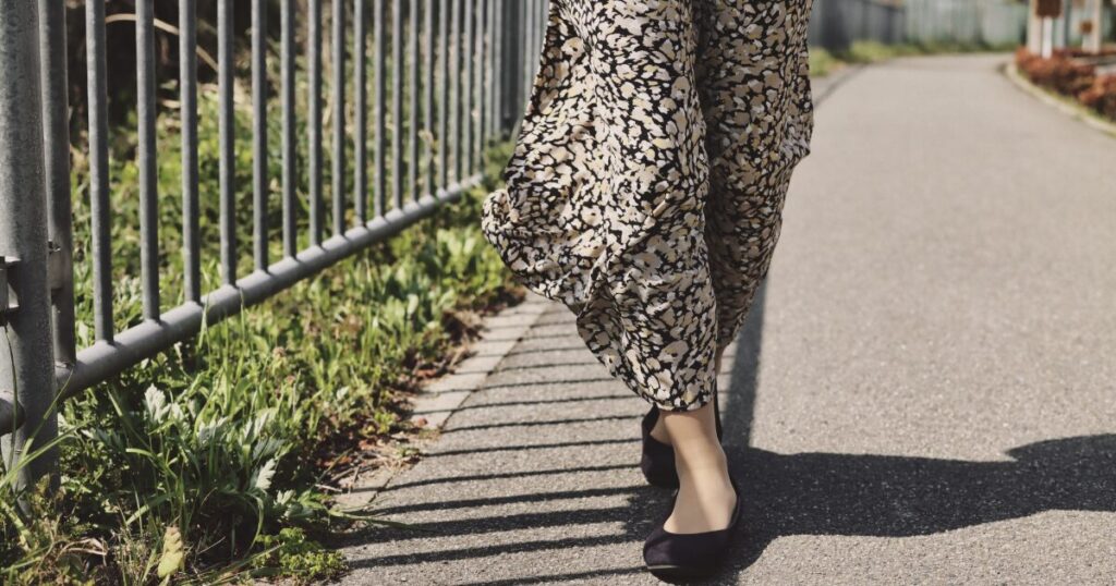 花柄ワンピースとバレエシューズで歩く女性