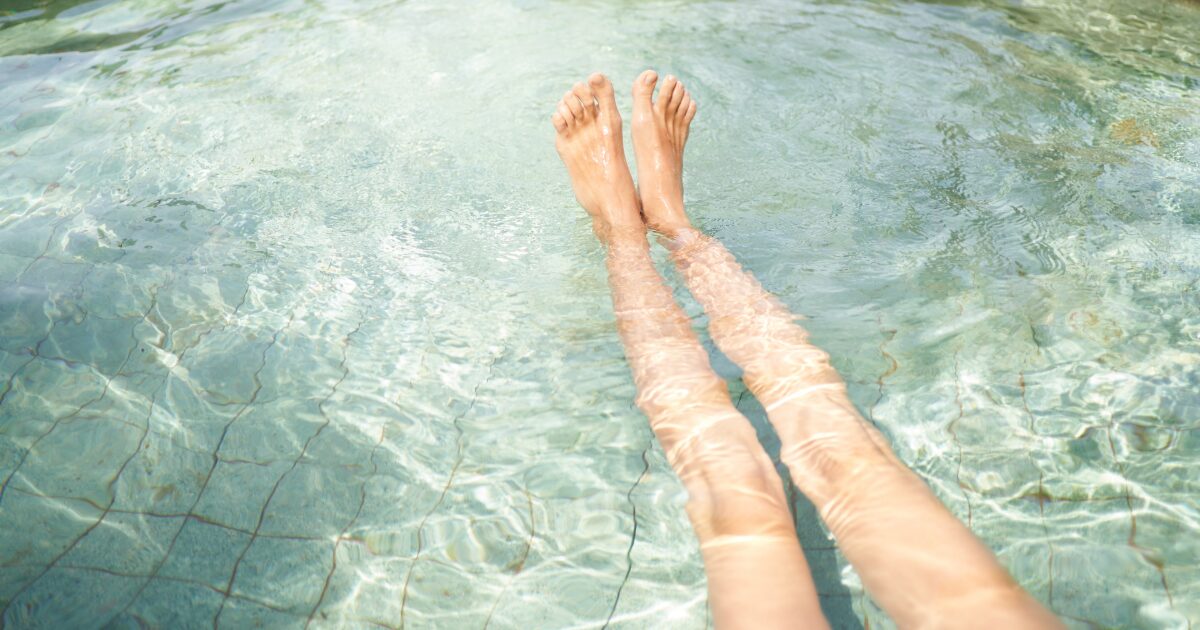 プールで足を水に浸ける女性