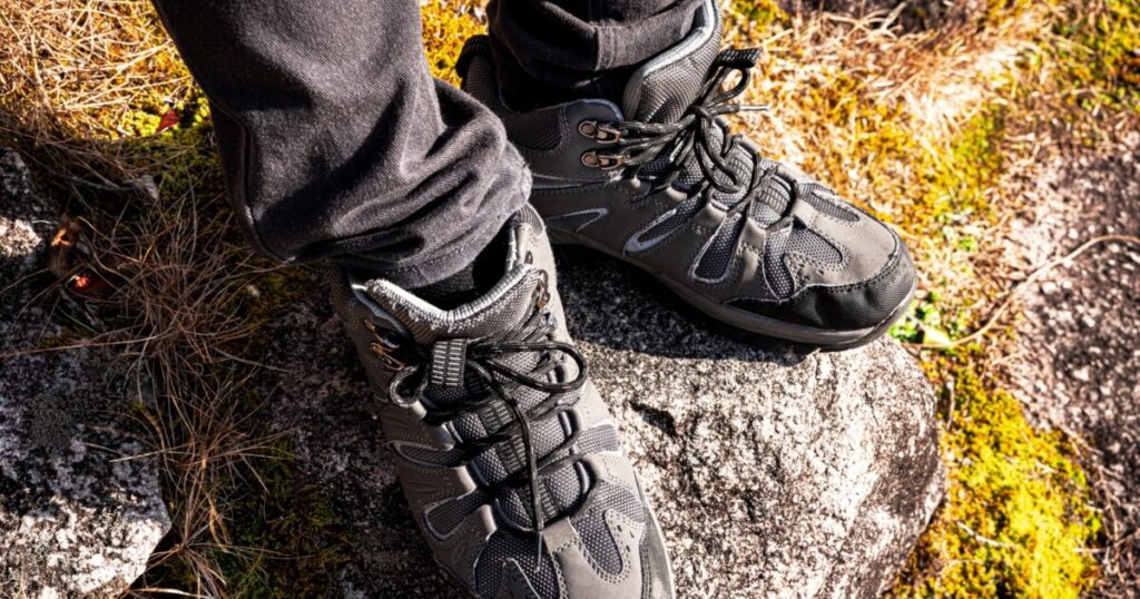 黒い登山パンツとハイキングシューズを履いた足元