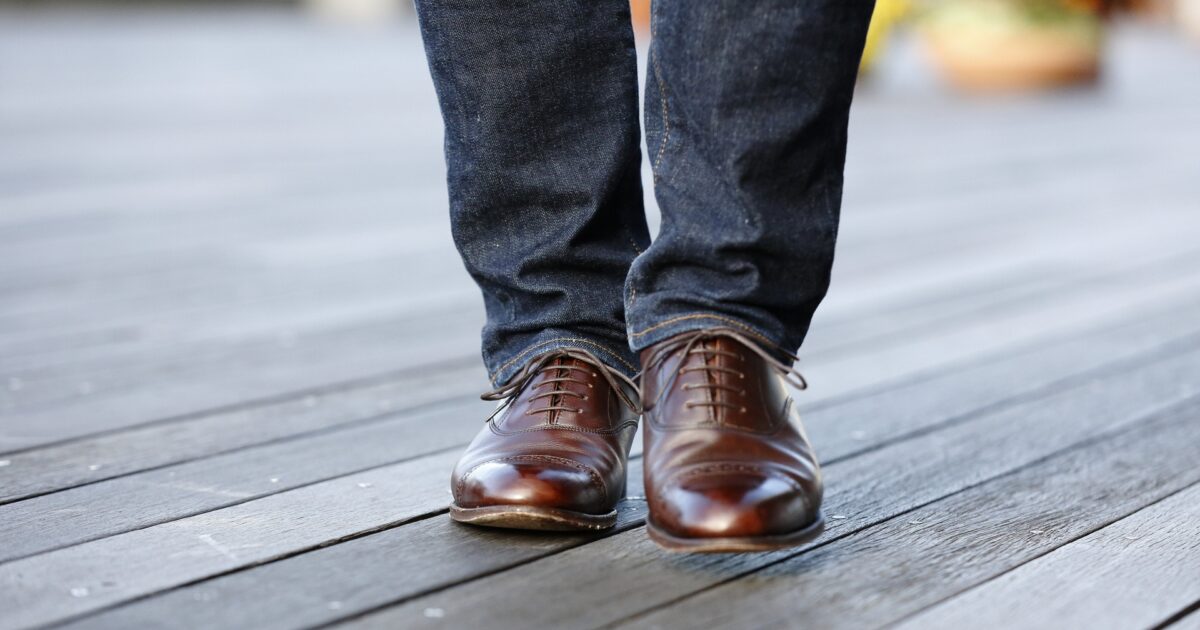 デニムとブラウンの革靴を履いた足元のアップ