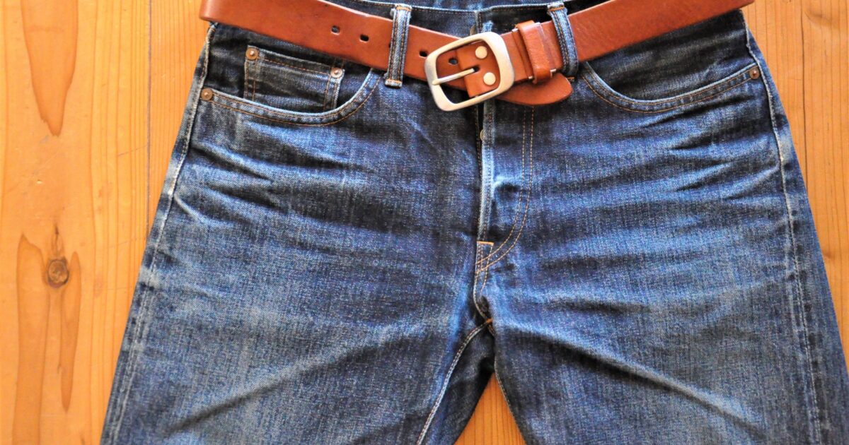 ブラウンベルト付きの色落ちデニムジーンズ