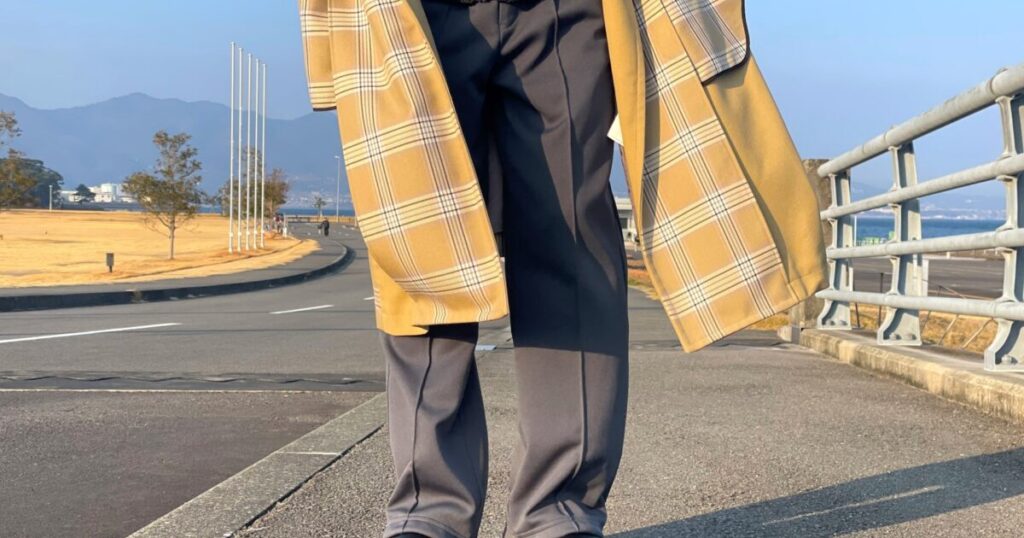 チェック柄コートとスラックスを着た人物の屋外での足元
