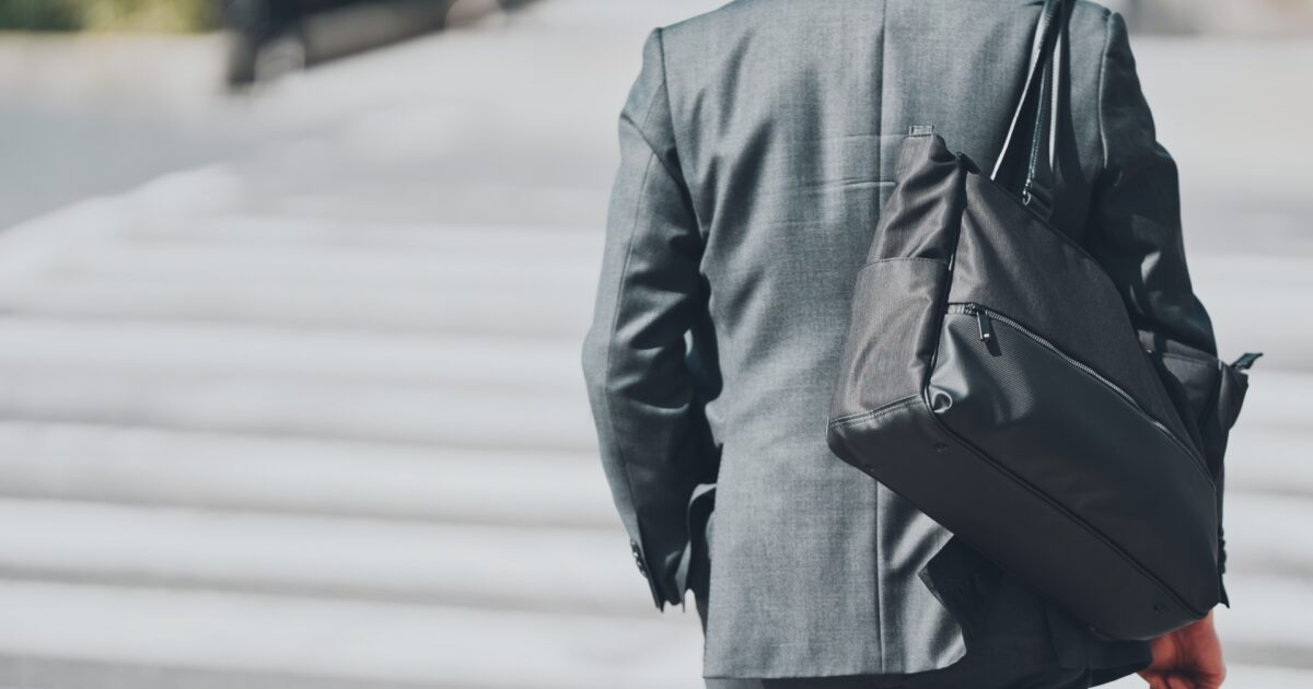 グレースーツを着たビジネスマンの後ろ姿とビジネスバッグ